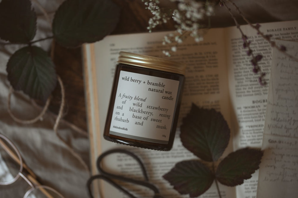wild berry and bramble candle lying on a book with leaves